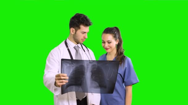 医師と看護師は 緑色の画面上に隔離された肺の放射線撮影を分析クロマキー背景 — ストック動画