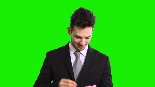 黒のスーツのビジネスマンは 緑の画面のクロマキーに隔離された貯金箱を保持 — ストック動画