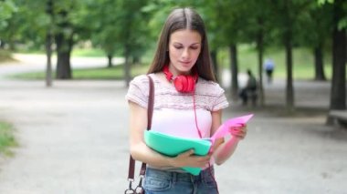 Gülümseyen öğrenci dışarıda yürüyor.