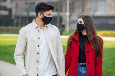 Çiftler covid veya coronavirus salgını sırasında şehirde birlikte yürürler.