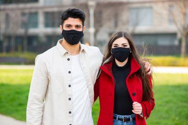 Maske takan genç bir çiftin portresi, covid ve coronavirus konsepti