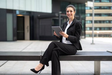 Gülümseyen iş kadını dijital tablet kullanıyor.
