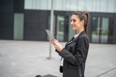 Gülümseyen iş kadını dijital tablet kullanıyor.