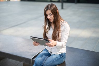 Gülümseyen iş kadını dijital tablet kullanıyor.