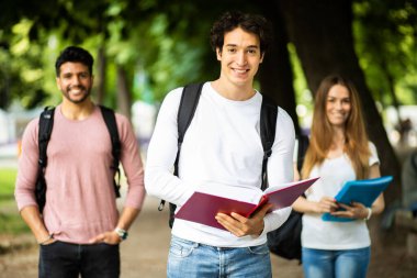 Dışarıdaki mutlu öğrenciler güvenle gülümsüyor.