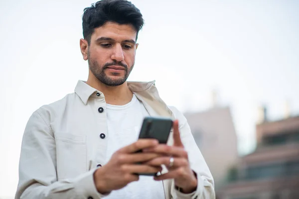 Man Met Behulp Van Zijn Smartphone Tijdens Het Lopen Een — Stockfoto