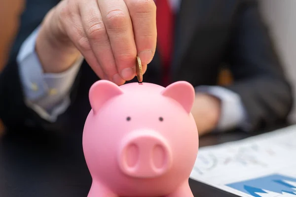Mann Legt Geld Sein Sparschwein — Stockfoto