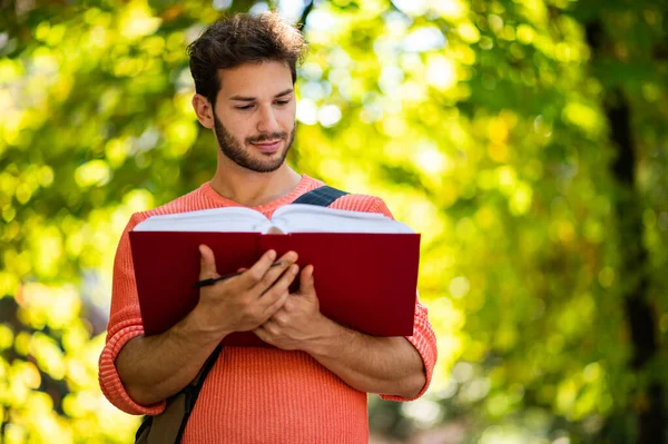 Jonge Mannelijke Student Die Een Boek Buiten Leest — Stockfoto