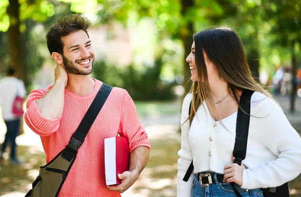 Dva Studenti Muž Žena Mluví Venku Vysokoškolském Parku Zatímco Drží — Stock fotografie