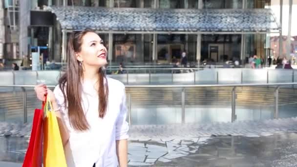Mujer Joven Sosteniendo Bolsas Compras Mientras Camina Una Ciudad — Vídeo de stock