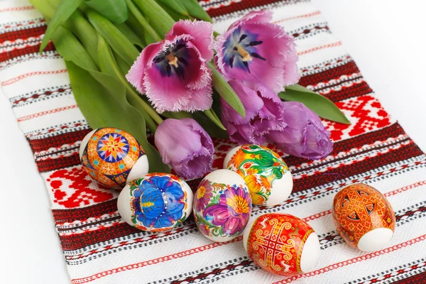 Пасхальные яйца и тюльпаны на полотенце — стоковое фото