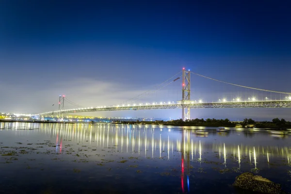 Gece denizde köprü yansıma — Stok fotoğraf