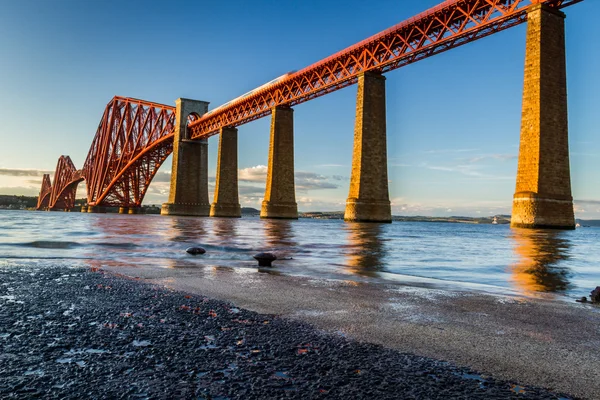 Tren que monta en el puente de Forth Road al atardecer —  Fotos de Stock