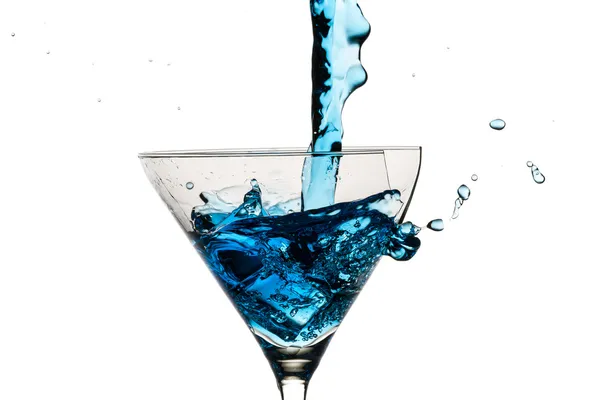 Cubos de hielo y vaso de martini rellenos de licor azul sobre ba blanca — Foto de Stock