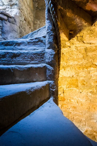 Stone Spiral Stairway med blandet lys i slottet - Stock-foto