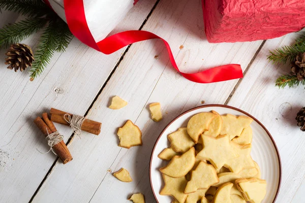 Gifts and Christmas cookies on old white table — Stock Photo, Image