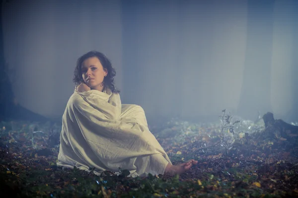 Donna perduta con lenzuolo bianco nella foresta scura — Foto Stock