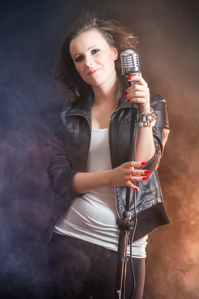 Beautiful singer with microphone on stage — Stock Photo, Image