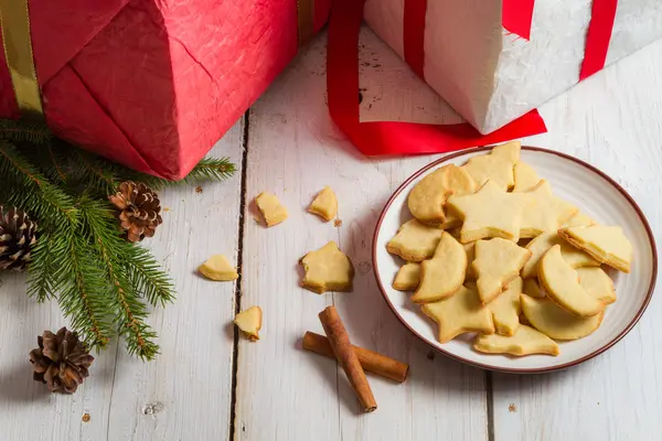 Zelfgemaakte ontbijtkoek kerstkoekjes op plaat en geschenken — Stockfoto