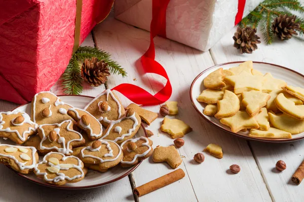 Lanchar biscoitos de Natal caseiros em um prato em presentes backgrou — Fotografia de Stock