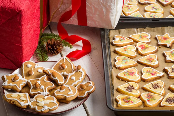 Regalos de Navidad y galletas caseras de jengibre en bandeja para hornear —  Fotos de Stock