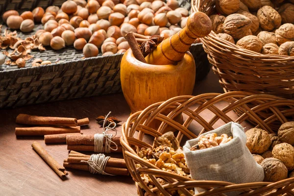 Valnötter, hasselnötter och kanel i flätade korgar — Stockfoto