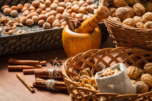 Walnüsse, Haselnüsse und Zimt in Weidenkörben — Stockfoto