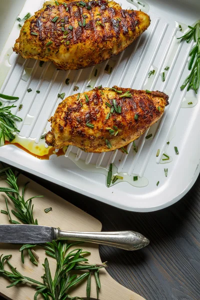 Two chicken breasts baked in a pan