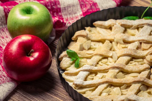 Closeup de maçãs e bolo de maçã decorado com açúcar de confeiteiro — Fotografia de Stock