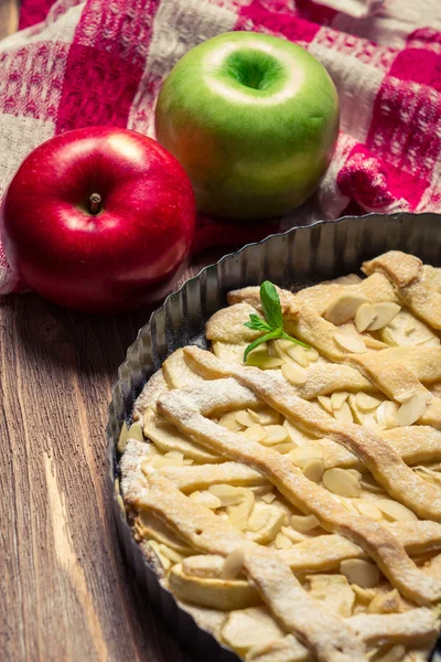 Maçãs e bolo de maçã com açúcar de confeiteiro e folha de hortelã — Fotografia de Stock