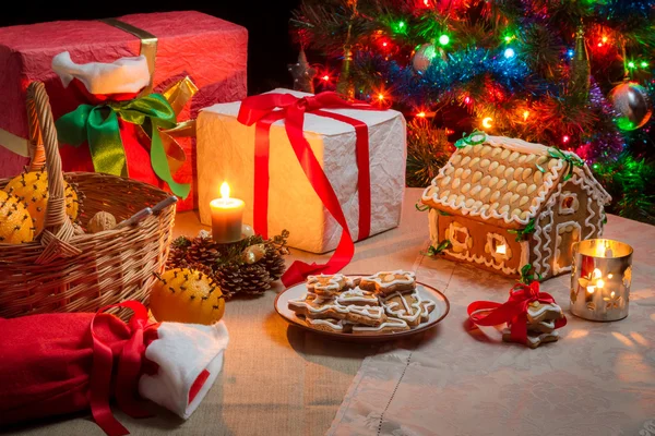 Presentes e biscoitos de gengibre na mesa na véspera de Natal — Fotografia de Stock