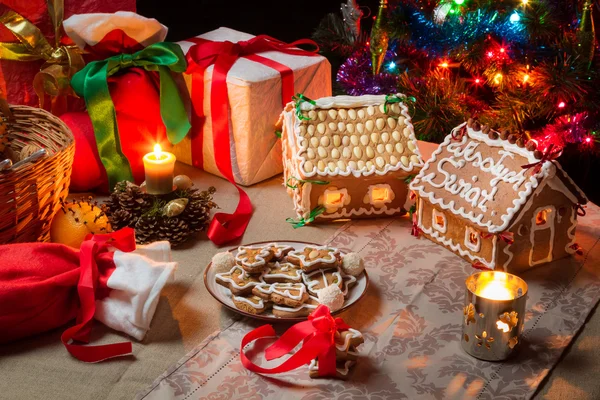 Casas e biscoitos de gengibre na mesa de Natal — Fotografia de Stock