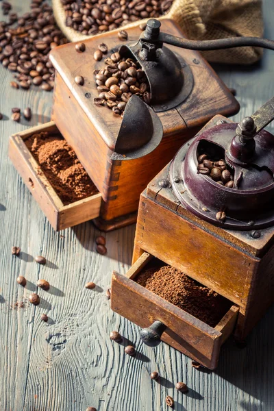 Two old coffee grinders on wooden table — Stock Photo, Image