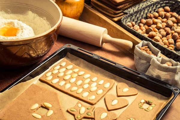 Decorating gingerbread cookies nuts just before baking — Stock Photo, Image