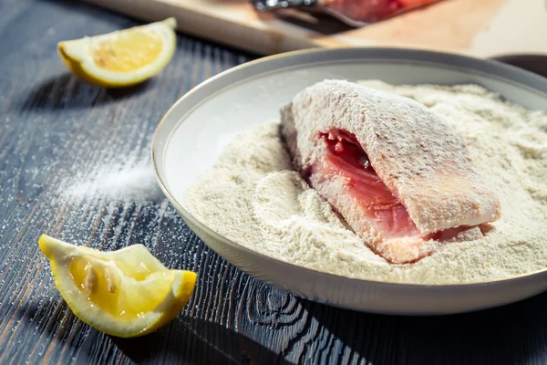 Primo piano di pesce fresco in farina e limone — Foto Stock