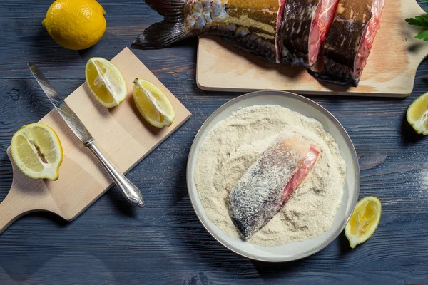 Fresh fish, flour and lemon as ingredients in a dish — Stock Photo, Image