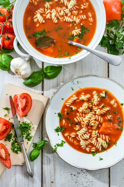 Sopa de tomate com macarrão e ingredientes na mesa de madeira velha — Fotografia de Stock