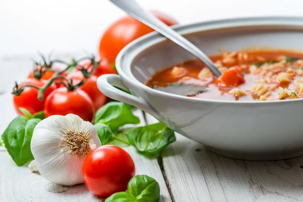 Крупный план томатного супа из чеснока и базилика — стоковое фото