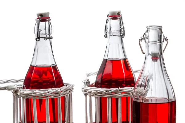Tre gamla flaskor med röd saft — Stockfoto