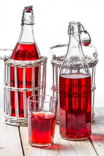 Closeup of red juice in vintage bottles on white background — Stock Photo, Image