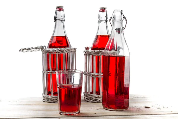 Vintage Flaschen mit rotem Saft auf weißem Hintergrund — Stockfoto