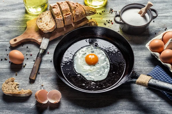 Τηγανητό αυγό σε ένα τηγάνι και σερβίρονται με ψωμί — Φωτογραφία Αρχείου