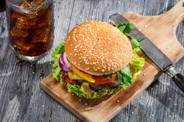 Hambúrguer caseiro e uma Cola com gelo — Fotografia de Stock