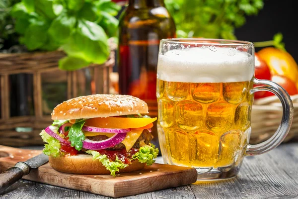 Primer plano de hamburguesa fresca y una cerveza fría — Foto de Stock