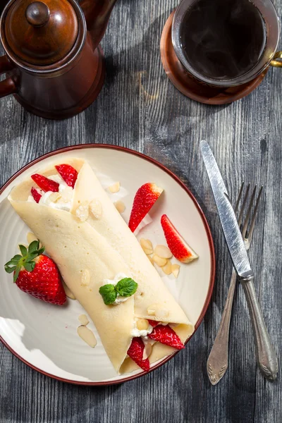 Café y panqueques con fresas servidos en el desayuno —  Fotos de Stock