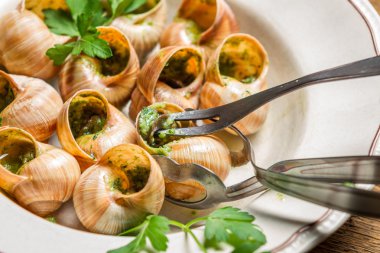 Closeup of eating the fried snails with garlic butter clipart