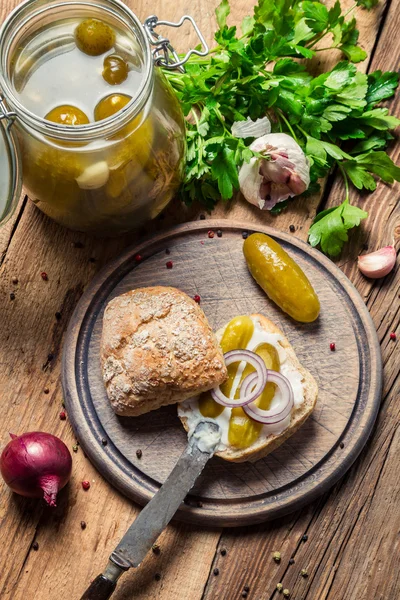 Preparing a sandwich with gherkin and lard — Stockfoto