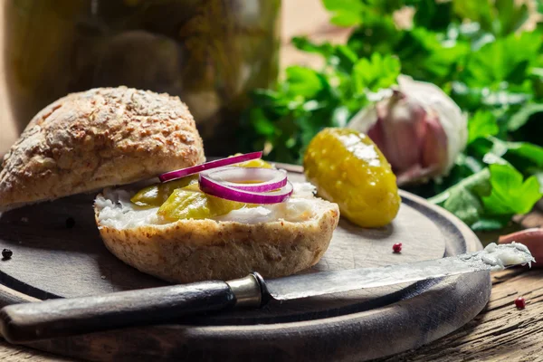 Fechar de um sanduíche com cebola, pepino em conserva e banha — Fotografia de Stock