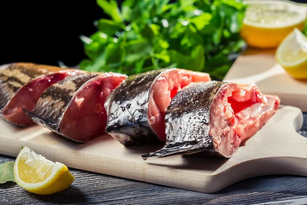 Fresh fish with lemon and salt on cutting board — Stock Photo, Image