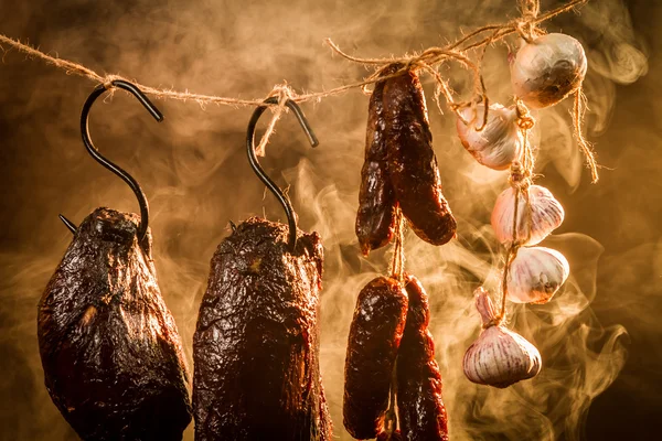 Jamón, salchicha y ajo en un ahumadero casero — Foto de Stock